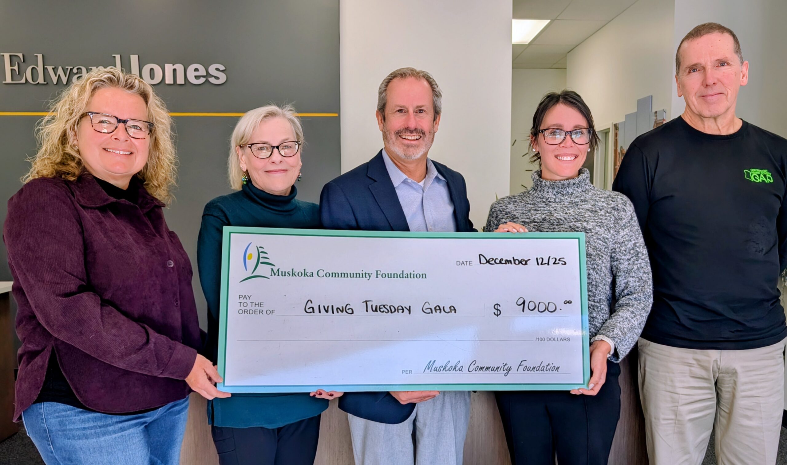 Jeff Barnes and Kendra Mitchell of Edward Jones present a cheque to Carrie Campbell (Executive Director of Enliven Cancer Care), Mary Ellen McIntyre (Executive Director of the Muskoka Community Foundation), and Peter Stolpmann (Executive Director of Gravenhurst Against Poverty).